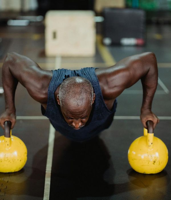Focused man holding a kettlebell, showing concentration and strength.