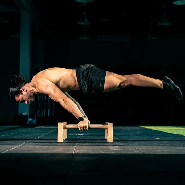 Man performing a controlled strength exercise in a minimalist gym setting.